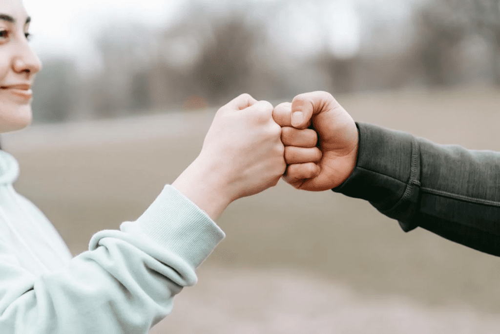 The man and woman exchange a friendly handshake at the park.